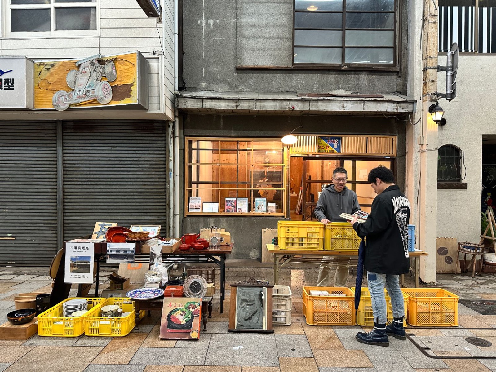 北ぶらくり丁の商店街に並べた古道具の販売スペース。店先で二人が品物を手に取っている